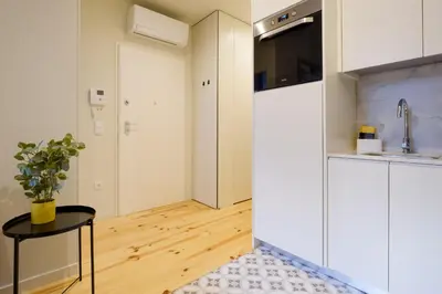 a kitchen with white cabinets and a table and a sink at Luxury Style 8 with AC Downtown Porto near Metro in Porto