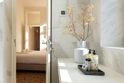 a bathroom with a table with a vase on it at Almada 559 - Eça Atelier by Lisbeyond in Porto