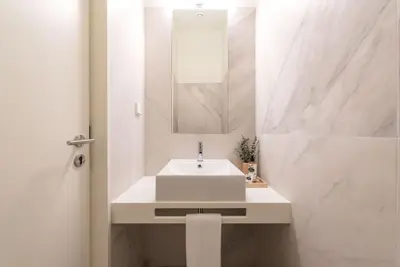 a white bathroom with a sink and a mirror at Almada 559 - Eça Atelier by Lisbeyond in Porto