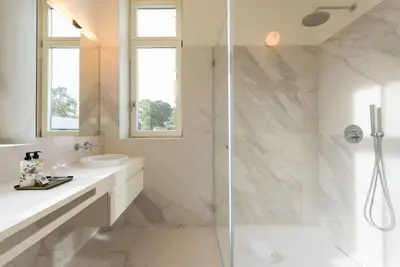 a white bathroom with a shower and a sink at Almada 559 - Ortigão Residence by Lisbeyond in Porto