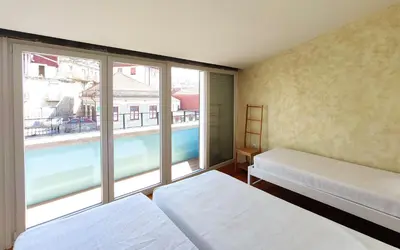 a room with two beds and a large window at Best Guest Porto Hostel in Porto