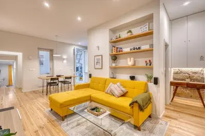 a living room with a yellow couch and a table at OPORTO GUEST Alegria126 in Porto