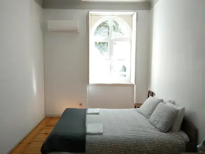 a bedroom with a bed and a window at Carolina M Apartment in front of Metro in Porto