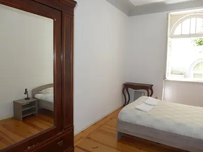a bedroom with a mirror and a bed and a window at Carolina M Apartment in front of Metro in Porto