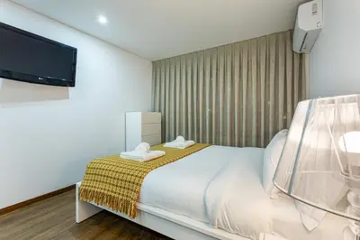 a bedroom with a bed and a flat screen tv at Luxury House by ON Apartments in Porto
