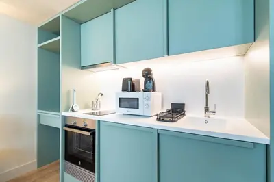 a kitchen with blue cabinets and a microwave at Bonjardim Suites in Porto