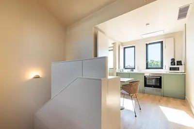 a kitchen with a white refrigerator and a table at Bonjardim Suites in Porto