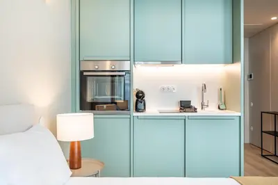 a kitchen with blue cabinets and a stove top oven at Bonjardim Suites in Porto