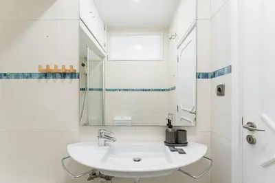 a white bathroom with a sink and a mirror at GuestReady - Fantastic house in the city center in Porto
