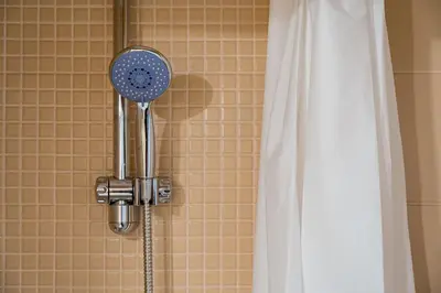 a shower with a blow dryer next to a shower curtain at GuestReady - Fantastic house in the city center in Porto