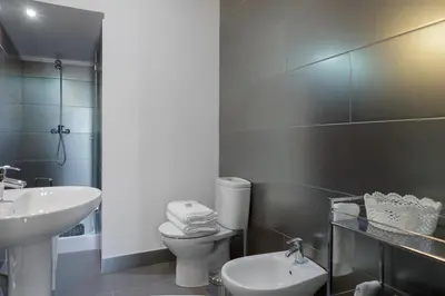 a white bathroom with a sink and a toilet at Almond Biscuit Porto Historic Center in Porto