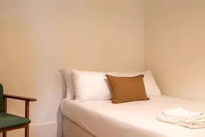 a room with a bed with a pillow and a chair at Riverfront Heritage House in Vila Nova de Gaia