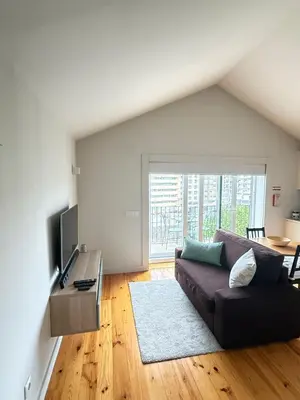 a living room with a couch and a large window at Bonjardim Bright Studio in Porto