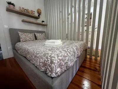 a bedroom with a bed with a gray bedspread at Bonjardim Bright Studio in Porto
