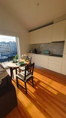 a living room with a table and a kitchen at Bonjardim Bright Studio in Porto