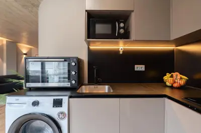 a kitchen with a microwave and a washing machine at Modern & Cozy Flats with Terrace by HostWise in Porto