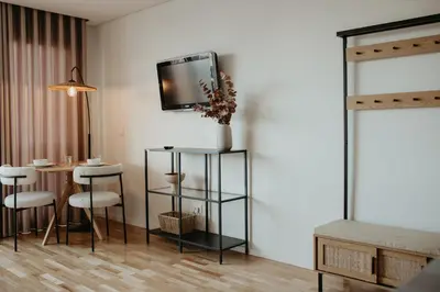 a living room with a table and a tv on a wall at Bolhão Downtown in Porto
