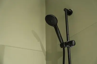 a black shower head in a bathroom with a wall at GuestReady - Crown Garden Escape in Porto