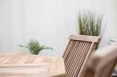 a wooden chair sitting next to a wooden table at GuestReady - Crown Garden Escape in Porto