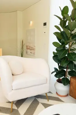 a white couch in a living room with a plant at The Luminous by Lovely Memories - Pool Access in Porto