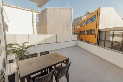 a balcony with a wooden table and chairs on a building at Cozy Bonfim by Hosty in Porto