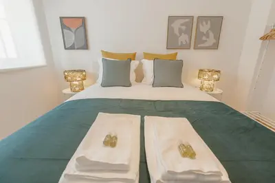 a bedroom with a large bed with towels on it at Cozy Bonfim by Hosty in Porto