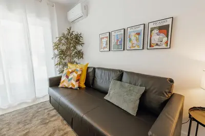 a living room with a brown leather couch at Cozy Bonfim by Hosty in Porto