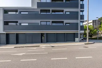 a building with two garage doors on the side of a street at Nomad's Lux - 2bdr & Parking Flores Square Porto in Porto