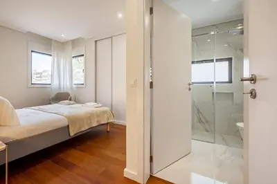 a bedroom with a bed and a glass shower at Nomad's Lux - 2bdr & Parking Flores Square Porto in Porto