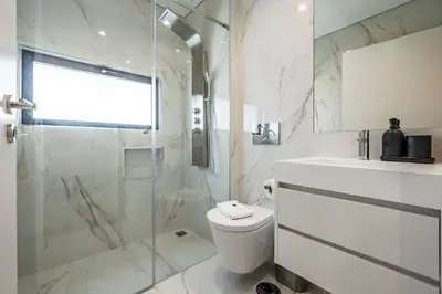 a bathroom with a toilet and a glass shower at Nomad's Lux - 2bdr & Parking Flores Square Porto in Porto