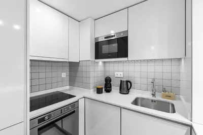 a white bathroom with a shower and a sink at Bright Apartment with Balcony & Parking | Bonfim in Porto