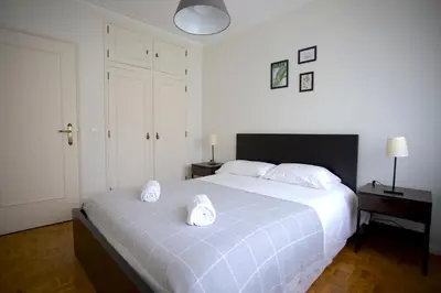 a bedroom with a bed with two white towels on it at 2Bedroom Flat - Families, remote work, downtown - Private Garage in Porto