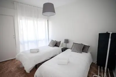 two twin beds in a room with a window at Quiet 3BR Flat - City Center - Warm and Bright - Remote Work in Porto