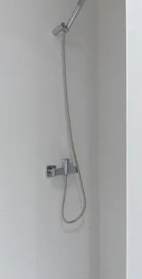 a shower head is hanging on a wall at Charming Flat - Garage by Host Wise in Porto