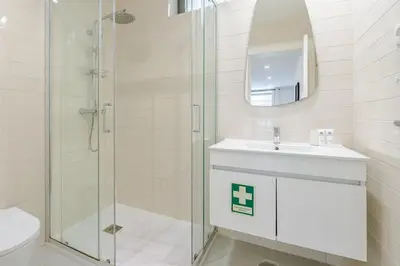 a white bathroom with a sink and a shower at Bright & Characterful Home by HostWise in Porto