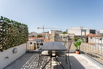 a table and chairs sitting on a balcony at GuestReady - Top floor lodge with a stunning view in Porto