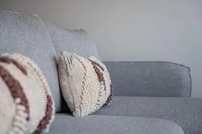 a gray couch with two pillows on it at GuestReady - Top floor lodge with a stunning view in Porto