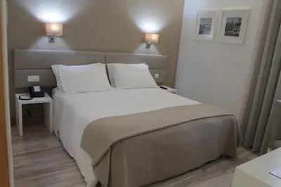 a bedroom with a large bed with white sheets and pillows at Seculo Soft in Porto