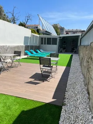 a patio with chairs and tables and a wall at Seculo Soft in Porto
