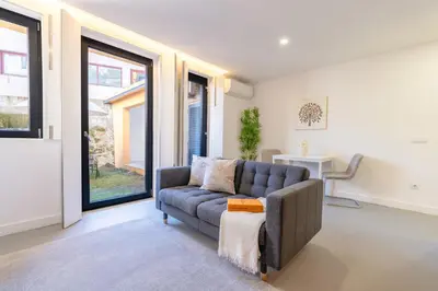 a living room with a couch and large windows at Bonfim Charming Flats by HostWise in Porto