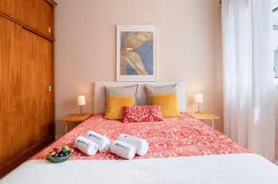 a bedroom with a bed with four pillows on it at The Heritage Flat in Porto