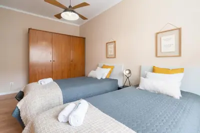 two twin beds in a bedroom with wooden cabinets at The Heritage Flat in Porto