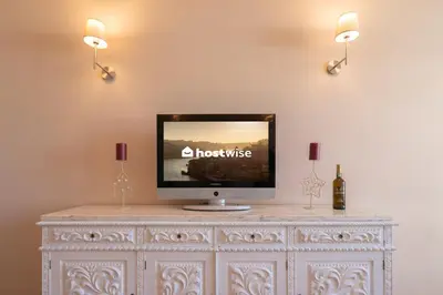 a tv on top of a white dresser with two lights at The Heritage Flat in Porto