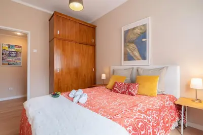 a bedroom with a large bed and a wooden cabinet at The Heritage Flat in Porto