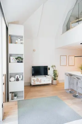 a white living room with a television and a table at Casa de Santa Catarina by OportoSoul in Porto