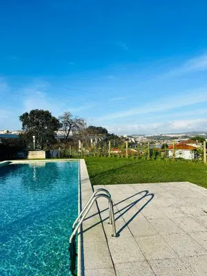 a swimming pool with a chair sitting next to it at Skyline Heaven - Fantastic View - Pool - Garage in Vila Nova de Gaia