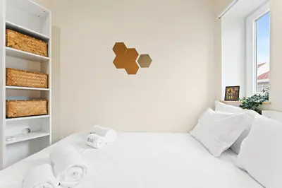 a white bedroom with a white bed and a window at GuestReady- Charming Porto Retreat with Terrace in Porto
