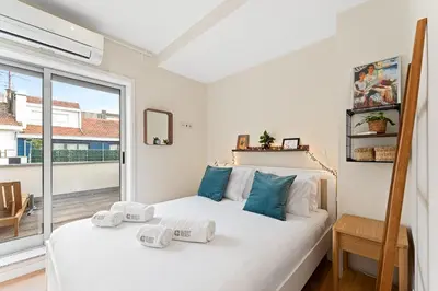 a bedroom with a white bed with blue pillows at GuestReady- Charming Porto Retreat with Terrace in Porto
