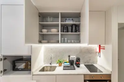 a kitchen with white cabinets and a sink at Oporto Center Studio in Porto