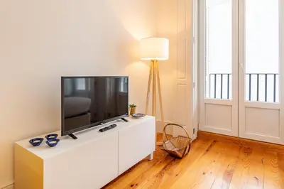 a living room with a flat screen tv on a white cabinet at Oporto Center Studio in Porto